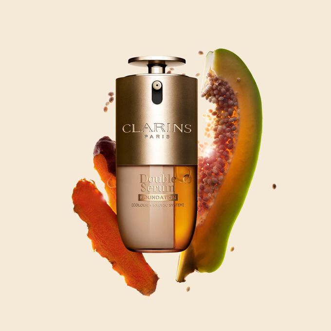 Produktbild av Clarins Double Serum Foundation tillg&auml;nglig f&ouml;r alla hudtoner, med nyckelingredienserna gurkmeja och papain.