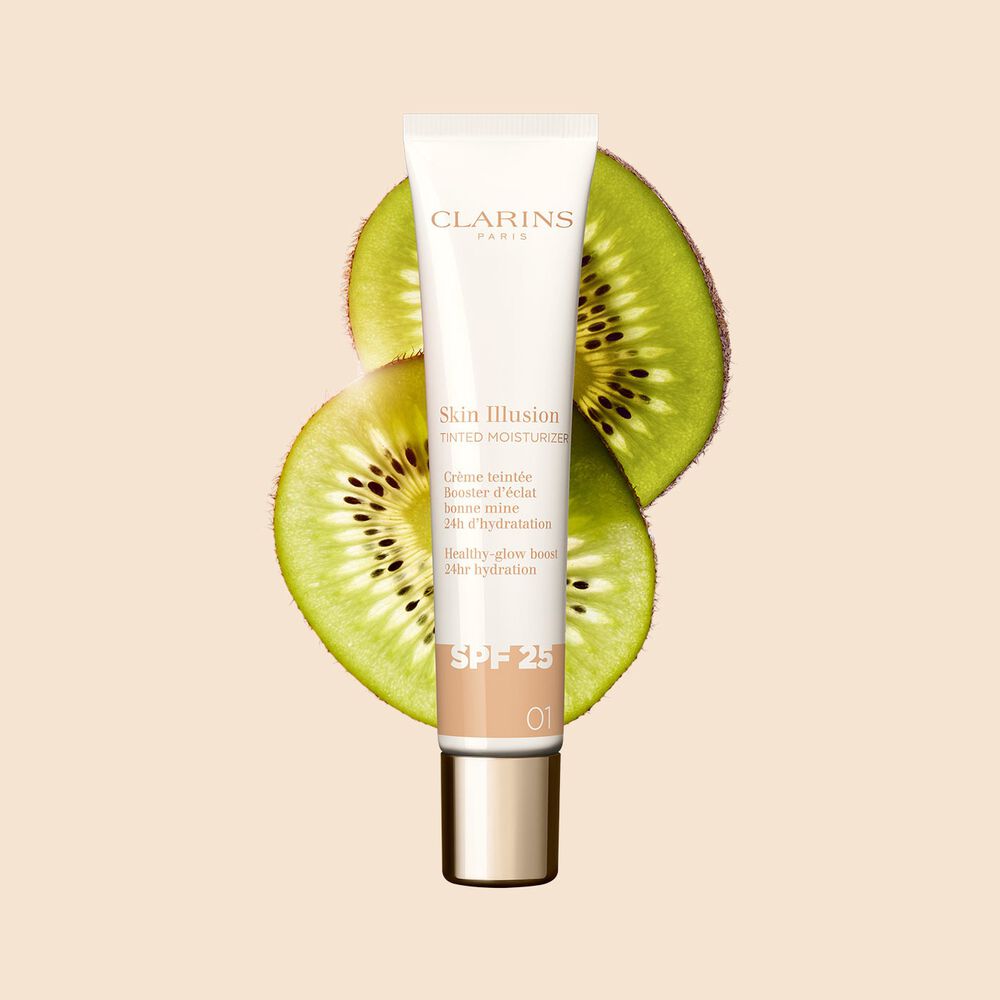 Packshot av 40-ml-tuben med Skin Perfector Skin Illusion Tinted Moisturizer nyans 01, placerad bredvid kiwibilder