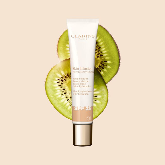Packshot av 40-ml-tuben med Skin Perfector Skin Illusion Tinted Moisturizer nyans 01, placerad bredvid kiwibilder
