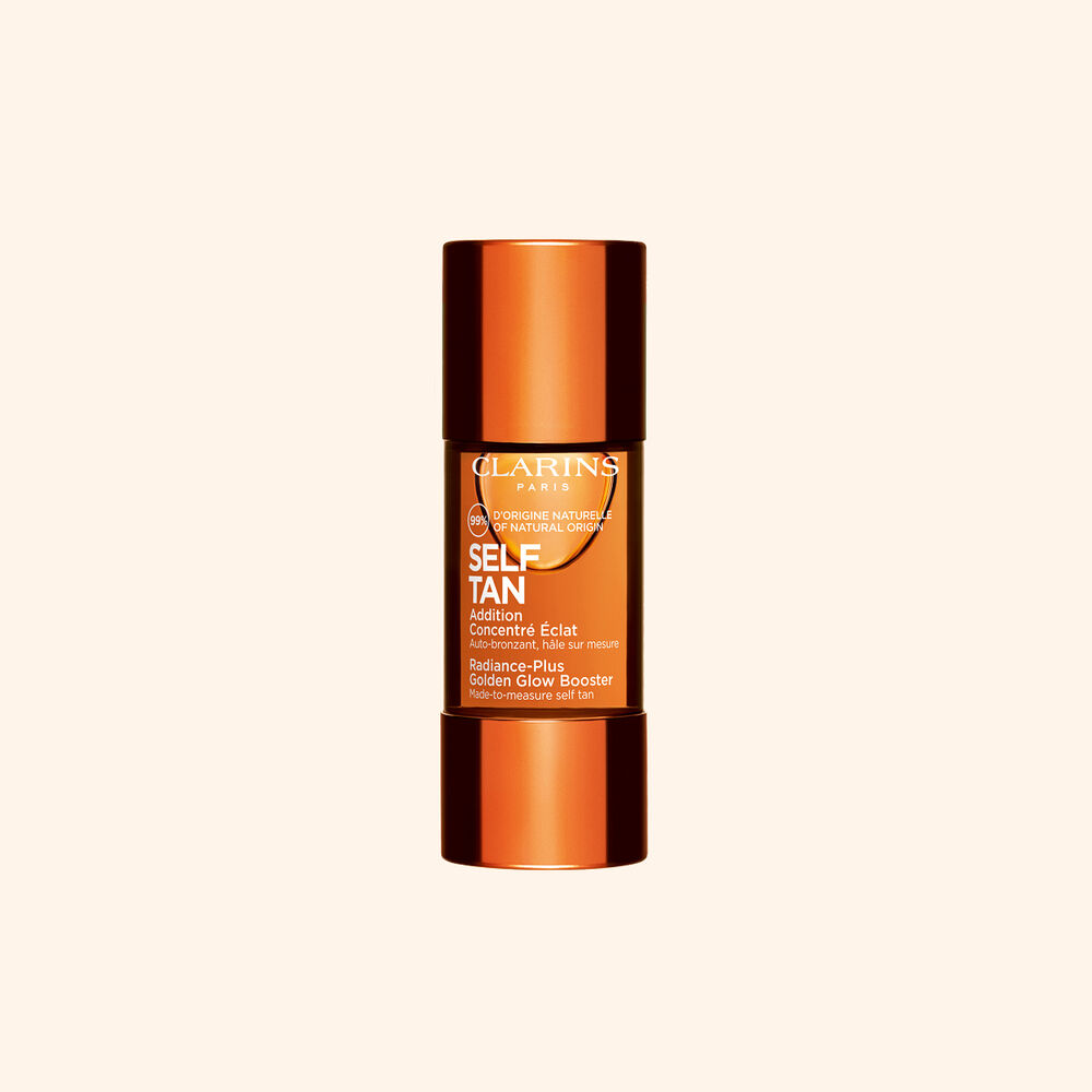 Clarins sj&auml;lvbrunande glow booster-flaska visas mot beige bakgrund f&ouml;r en solkysst str&aring;lande hudrutin.