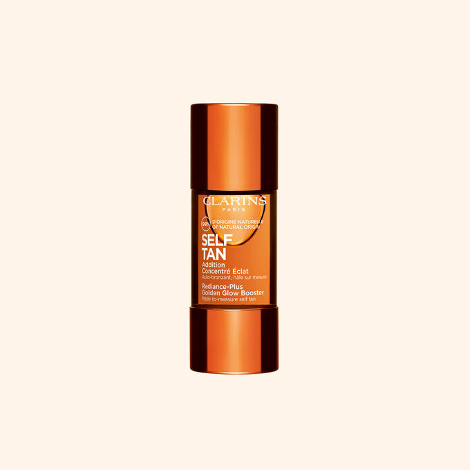Clarins sj&auml;lvbrunande glow booster-flaska visas mot beige bakgrund f&ouml;r en solkysst str&aring;lande hudrutin.