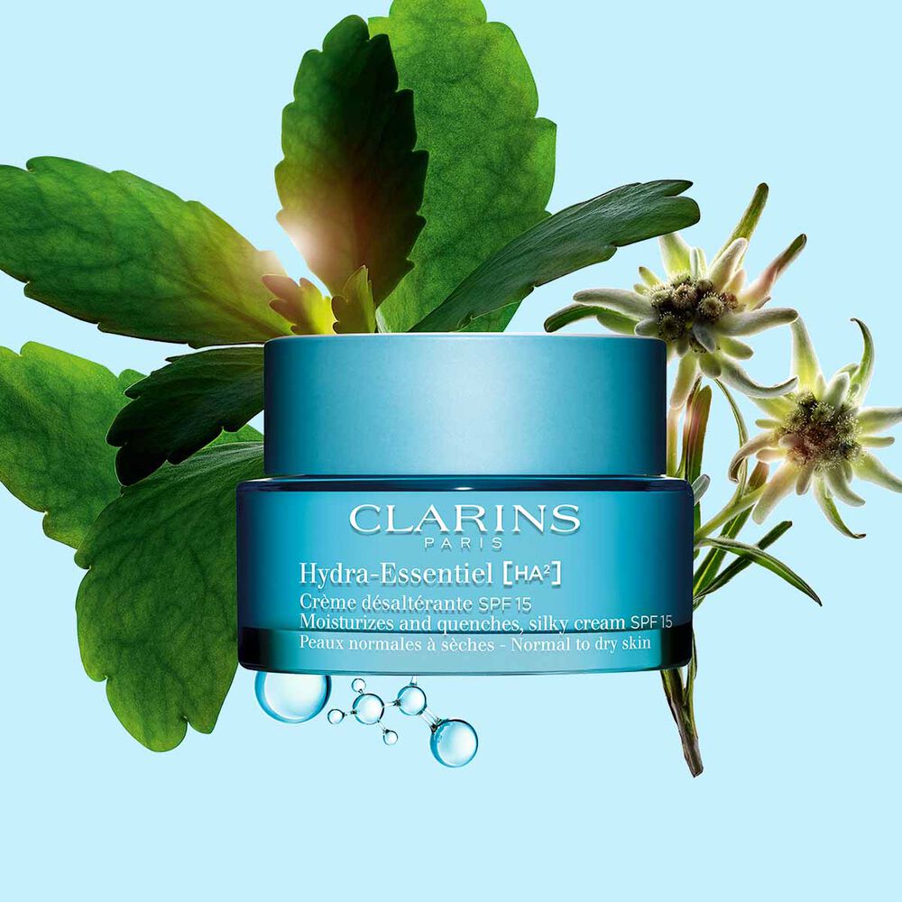 Packshot av Clarins Hydra-Essentiel SPF15 nära några edelweissblommor mot en blå bakgrund.