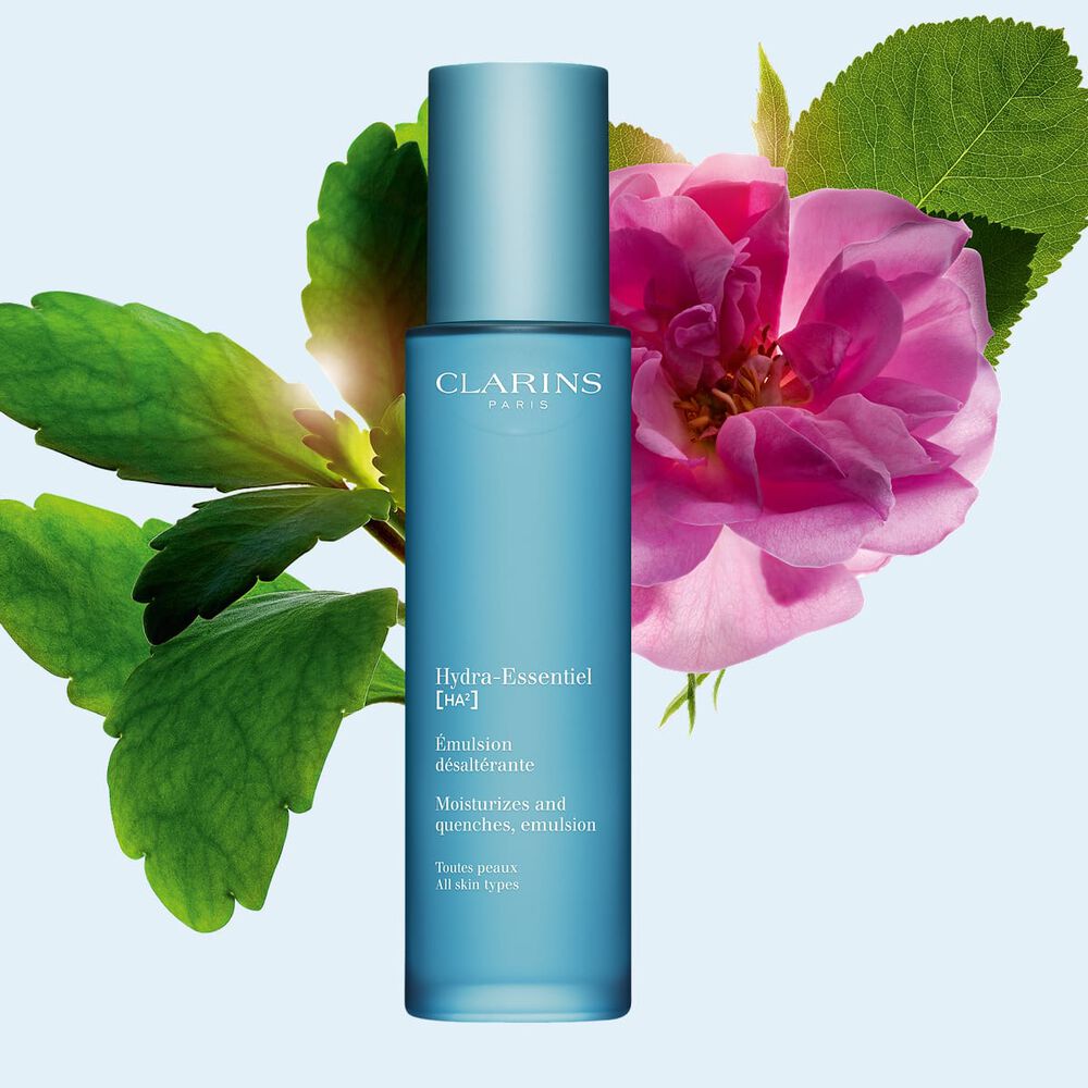 Packshot av Clarins Hydra-Essentiel 23 Emulsion n&auml;ra en damascenerros och ett kalankoeblad mot en bl&aring; bakgrund.
