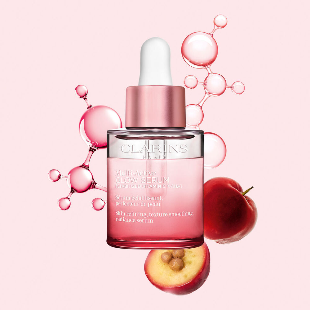 Packshot av Multi-Active Glow Serum med C-vitaminmolekyl och acerola på en ljusrosa bakgrund, som framhäver hudens lyster.