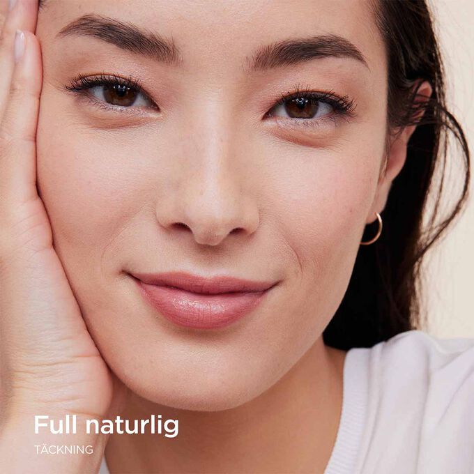 Kvinna som b&auml;r Clarins Skin Illusion Full Coverage foundation och visar upp full t&auml;ckning med ett naturligt resultat.