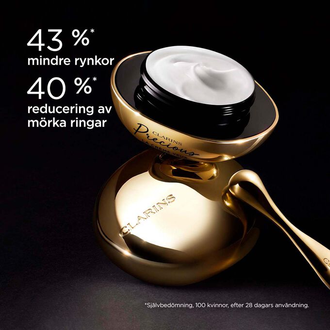 Ögonkrämen Clarins Precious Eyes mot en mörk bakgrund, med text som framhäver dess föryngrande effekt som får huden att se fem år yngre ut